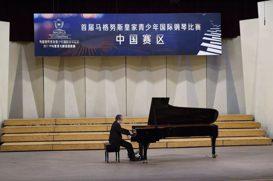 2019年历史原刊照片:旧名中国赛区横幅下,一名钢琴演奏者在舞台钢琴前演奏
